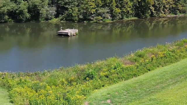 A floating dock on a pond, shot from the air